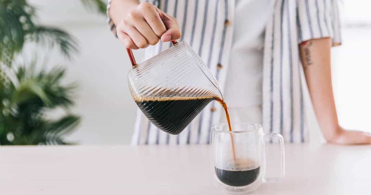 person pouring drip coffee