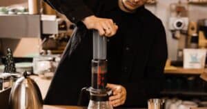 barista using an AeroPress coffee maker